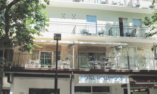 Hotel Hollywood con balconi e terrazza, circondato da alberi.